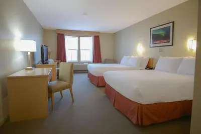 a hotel room with two beds and a desk at Eldorado, a Coast Hotel in Dawson City
