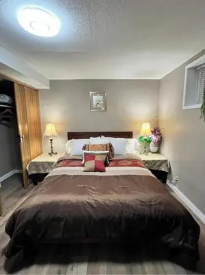 a bedroom with a large bed with two lamps at West Edmonton Perle Palace in Edmonton