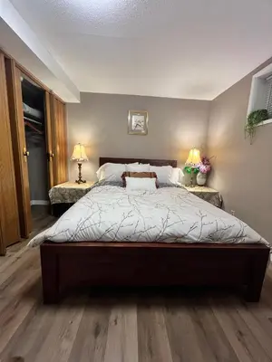 a bedroom with a large bed and two lamps at West Edmonton Perle Palace in Edmonton