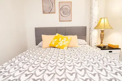 a bedroom with a bed with a gray and white bedspread at 3 Bedroom Gardenside Downtown Home in Whitehorse