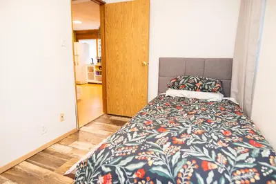 a bedroom with a bed with a colorful comforter at 3 Bedroom Gardenside Downtown Home in Whitehorse