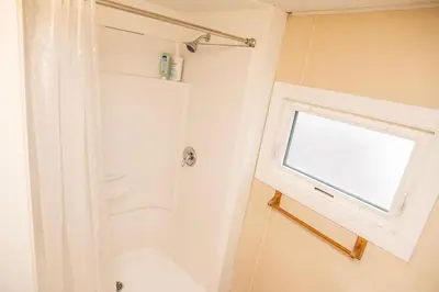 a bathroom with a shower and a window at 3 Bedroom Gardenside Downtown Home in Whitehorse