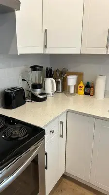 a kitchen with white cabinets and a stove top oven at New, Spacious 2 Bedrooms in Downtown With Free Parking! in Maple Ridge District Municipality