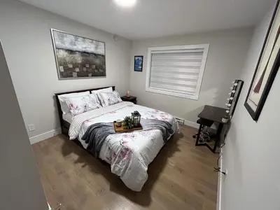 a bedroom with a bed with a table on it at New, Spacious 2 Bedrooms in Downtown With Free Parking! in Maple Ridge District Municipality