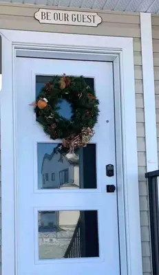 a white door with a wreath and a sign on it at New Townhouse in Red Deer in Red Deer