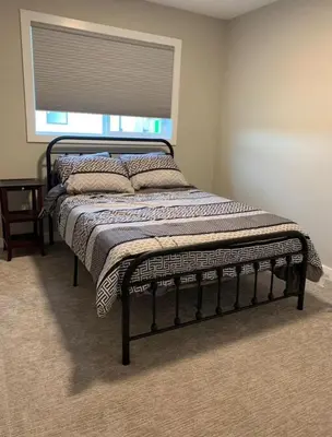 a bed in a room with a window at New Townhouse in Red Deer in Red Deer