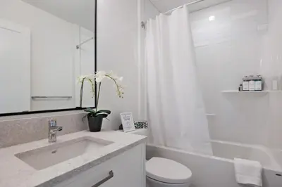 a white bathroom with a sink and a toilet at Ocean's 7 at THE BEACH HOUSE in Campbell River