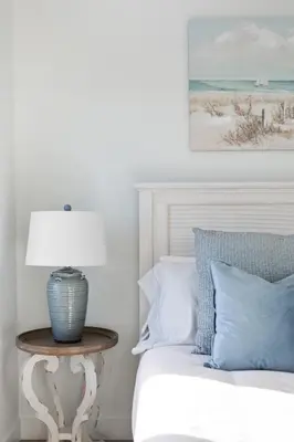 a bed with a table with a lamp on it at Ocean's 7 at THE BEACH HOUSE in Campbell River