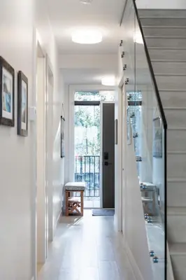 a hallway with white walls and a glass door at Ocean View Townhouse #26 at THE BEACH HOUSE in Campbell River