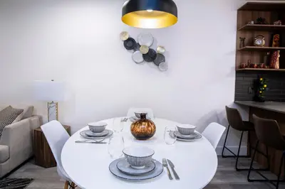 a white dining room with a white table and chairs at Revelstoke Marvel - Two Bedroom with Hot Tub in Revelstoke