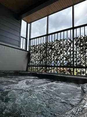 a balcony with a fence and a pool of water at Revelstoke Marvel - Two Bedroom with Hot Tub in Revelstoke
