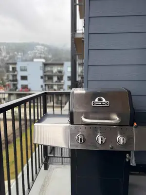 a grill sitting on the side of a balcony at Revelstoke Marvel - Two Bedroom with Hot Tub in Revelstoke