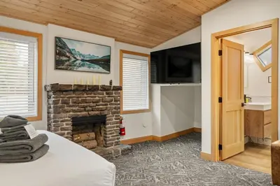 a room with a fireplace and a bed and a television at Elkhorn Lodge Vacation Rentals in Banff