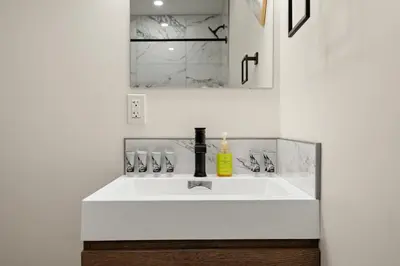 a bathroom with a white sink and a mirror at Elkhorn Lodge Vacation Rentals in Banff