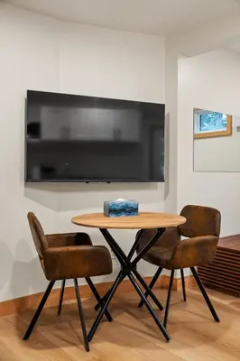 a table with two chairs and a television on a wall at Elkhorn Lodge Vacation Rentals in Banff