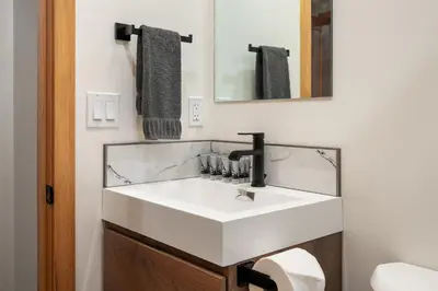 a bathroom with a white sink and a mirror at Elkhorn Lodge Vacation Rentals in Banff