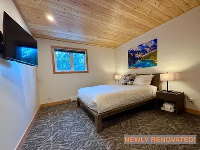 a bedroom with a bed with a wooden ceiling at Elkhorn Lodge Vacation Rentals in Banff