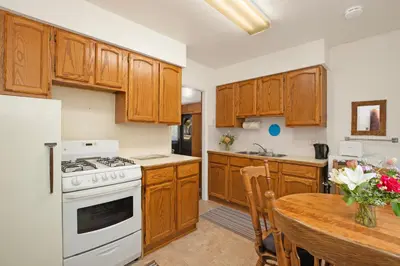 a kitchen with wooden cabinets and a table and a stove at Elkhorn Lodge Vacation Rentals in Banff