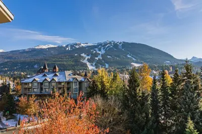 a house on a hill with a mountain in the background at Cascade by Elevate Vacations in Whistler