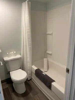 a white bathroom with a toilet and a bath tub at The 22 Hotel in Cremona