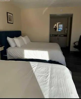 a hotel room with two beds and a mirror at The 22 Hotel in Cremona
