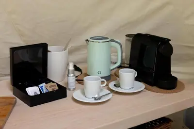 a table with a laptop and cups and a tv at Stay Wilder Sunshine Coast in Sechelt