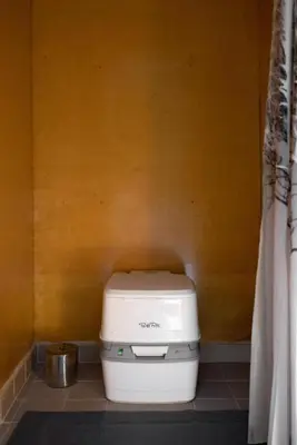 a toilet in a bathroom with a yellow wall at Stay Wilder Sunshine Coast in Sechelt