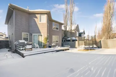 a house with a snow covered driveway at Cozy 2-Bedroom Basement Suite Retreat Calgary in Calgary