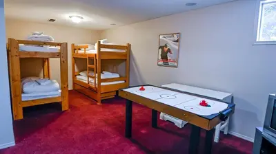 a room with two bunk beds and a table in it at Polar Peak Chalet by Fernie Lodging Company in Fernie