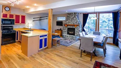 a kitchen and living room with a table and a fireplace at Polar Peak Chalet by Fernie Lodging Company in Fernie