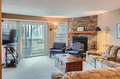 a living room with a couch and a fireplace at Ponderosa Inn by Okanagan Premier in Big White