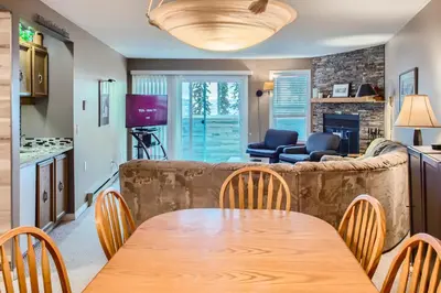 a dining room and living room with a table and chairs at Ponderosa Inn by Okanagan Premier in Big White