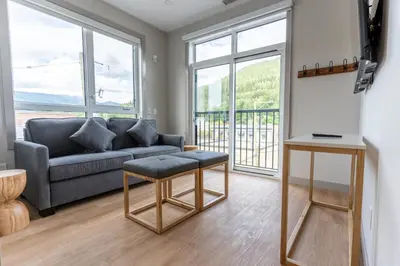 a living room with a couch and a table at Basecamp Suites Revelstoke in Revelstoke