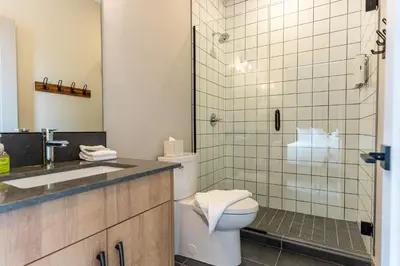 a bathroom with a toilet and a glass shower at Basecamp Suites Revelstoke in Revelstoke