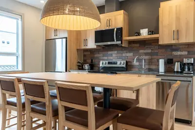 a kitchen with a large wooden table and chairs at Basecamp Suites Revelstoke in Revelstoke