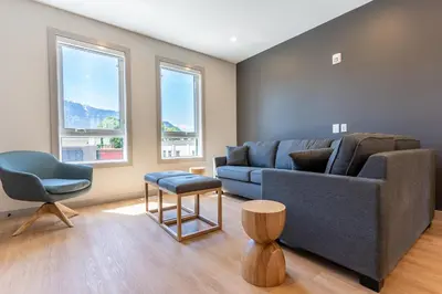 a living room with a blue couch and a chair at Basecamp Suites Revelstoke in Revelstoke