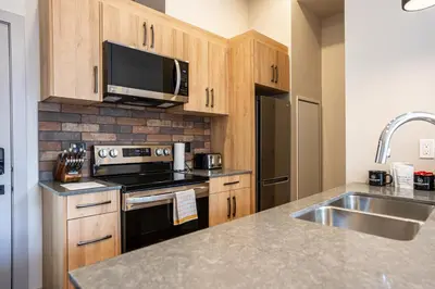 a kitchen with a sink and a microwave at Basecamp Suites Revelstoke in Revelstoke