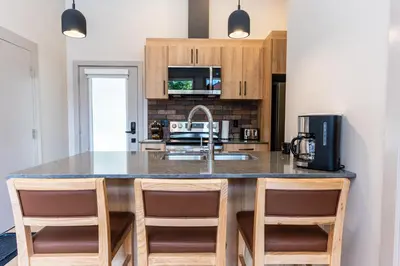 a kitchen with a large island with a counter top at Basecamp Suites Revelstoke in Revelstoke