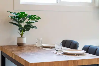 a table with plates and a potted plant on it at Coastal Creative Garden Studio in Colwood