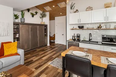 a kitchen and living room with a table and chairs at Coastal Creative Garden Studio in Colwood