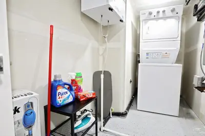 a small kitchen with a white refrigerator and a table at Queen Suite 20 Min from YEG Airport with Disney in Edmonton