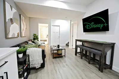 a living room with a table and a couch at Queen Suite 20 Min from YEG Airport with Disney in Edmonton