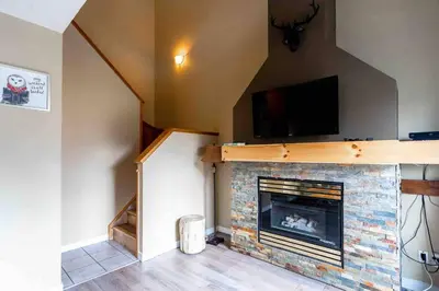 a living room with a fireplace with a flat screen tv at Mountain View 3br Loft Walk To Dt king fireplace in Canmore