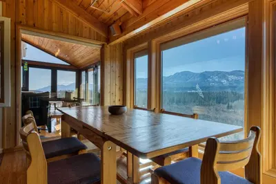 a dining room with a table and chairs and a large window at CLIFF CABIN Family Friendly|Hot Tub|Spectacular Views in Fairmont Hot Springs
