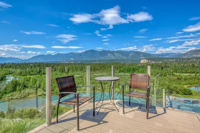 two chairs and a table on a deck with a view at CLIFF CABIN Family Friendly|Hot Tub|Spectacular Views in Fairmont Hot Springs