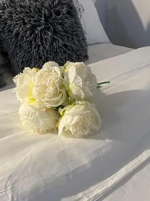 a bouquet of white flowers on a bed at Richard Comfort Living in Vancouver