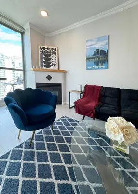 a living room with a blue couch and a fireplace at Richard Comfort Living in Vancouver
