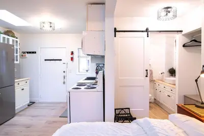a kitchen with white cabinets and a stove top oven at The Nook, Top Floor Suite with Lake and Mtn View in Harrison Hot Springs
