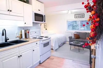 a kitchen and living room with a bed in a room at The Nook, Top Floor Suite with Lake and Mtn View in Harrison Hot Springs