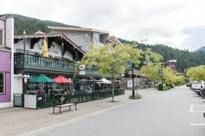 a street in a town with a building with a restaurant at The Nook, Top Floor Suite with Lake and Mtn View in Harrison Hot Springs